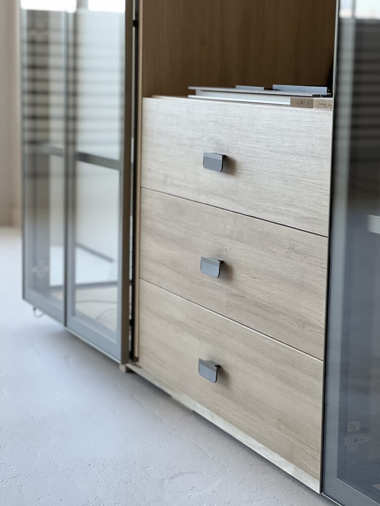 Glass cabinet with aluminum frame and wood drawers