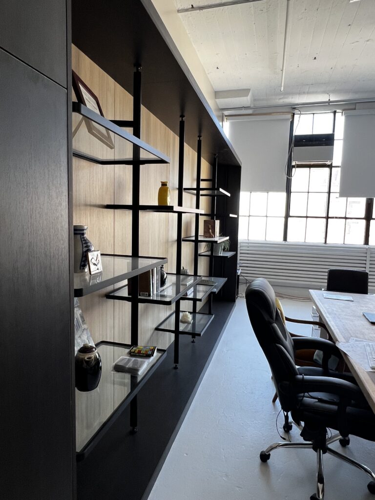 Aluminum display wall with shelving in an office