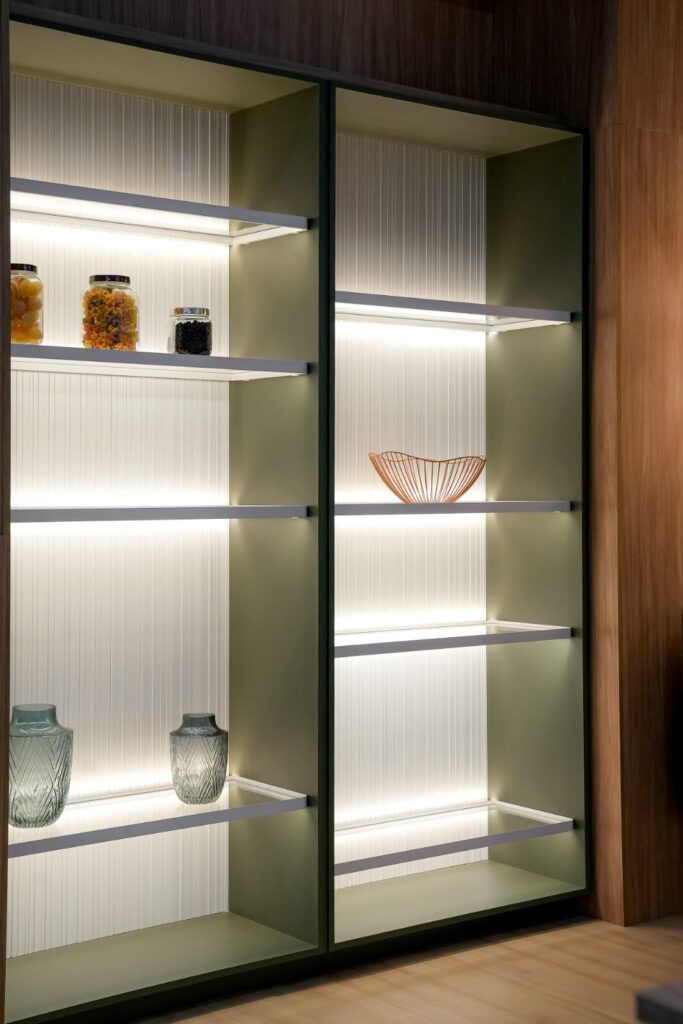 Lit glass shelves in an aluminum-framed cabinet