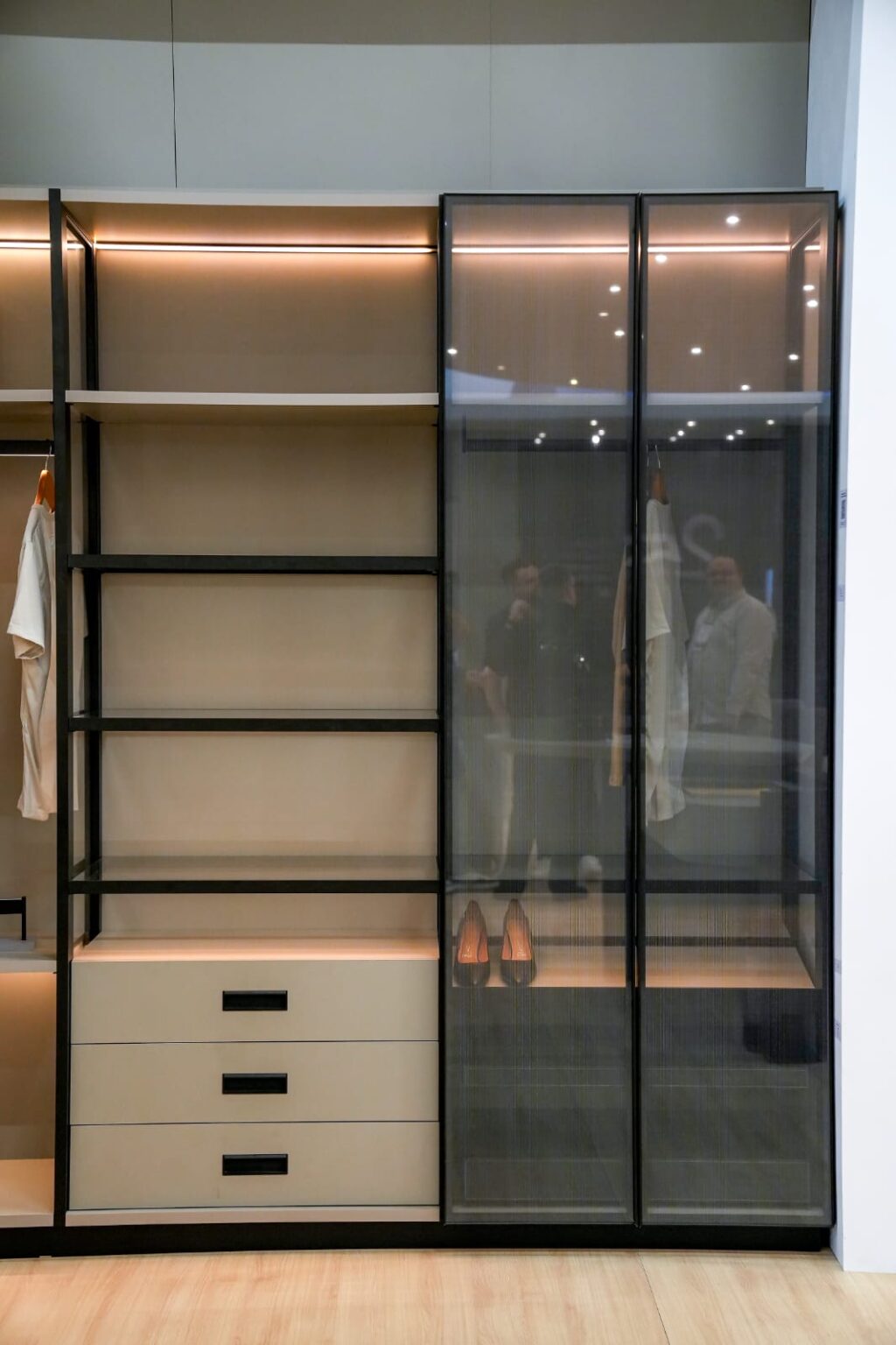 Aluminum-framed wardrobe with glass doors and lit shelves
