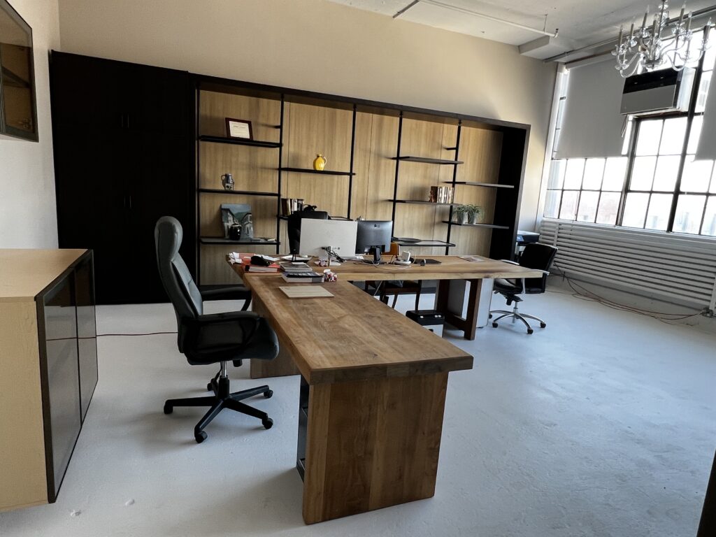 Aluminum display wall with shelving behind a desk