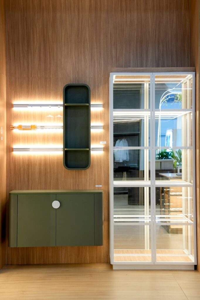 Wood-paneled wall with lit shelves and a glass cabinet